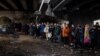 Жители на Ирпин се евакуират към Киев, минавайки под разрушен мост, 7 март 2022 г.