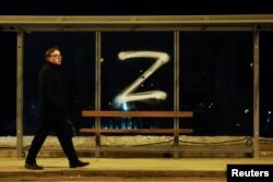 Një person kalon pranë një simboli 'Z' të vizatuar në një stacion autobusi në Shën Petersburg. 4 mars 2022.