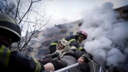 O fotografie publicată de Serviciul de Urgență al Ucrainei ilustrează cum pompierii evacuează o femeie în vârstă dintr-un bloc de apartamente lovit de bombardamentele în Kiev, luni, 14 martie 2022.