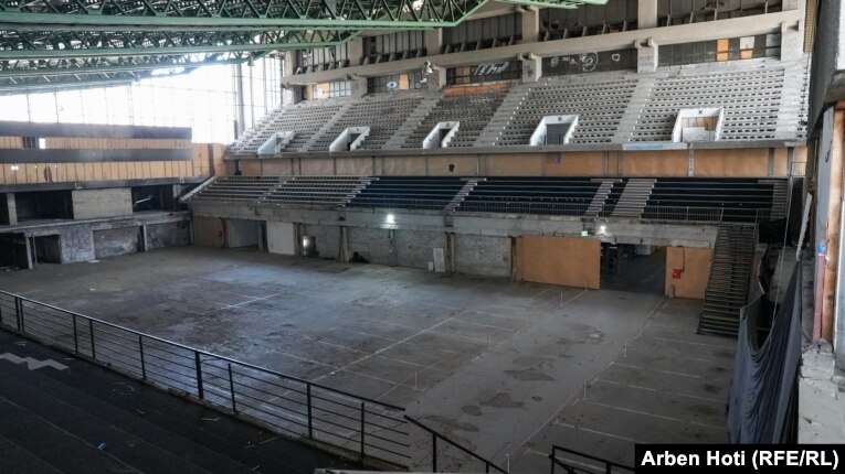 Brenda Pallatit t&euml; Rinis&euml; dhe Sporteve n&euml; Prishtin&euml;, i hapur p&euml;r her&euml; t&euml; par&euml; m&euml; 1977. Pallati duhet t'i n&euml;nshtrohet nj&euml; rinovim t&euml; plot&euml;, p&euml;rfshir&euml; sall&euml;n e madhe, sall&euml;n e djegur n&euml; vitin 2000, dhe hap&euml;sirat e tjera.