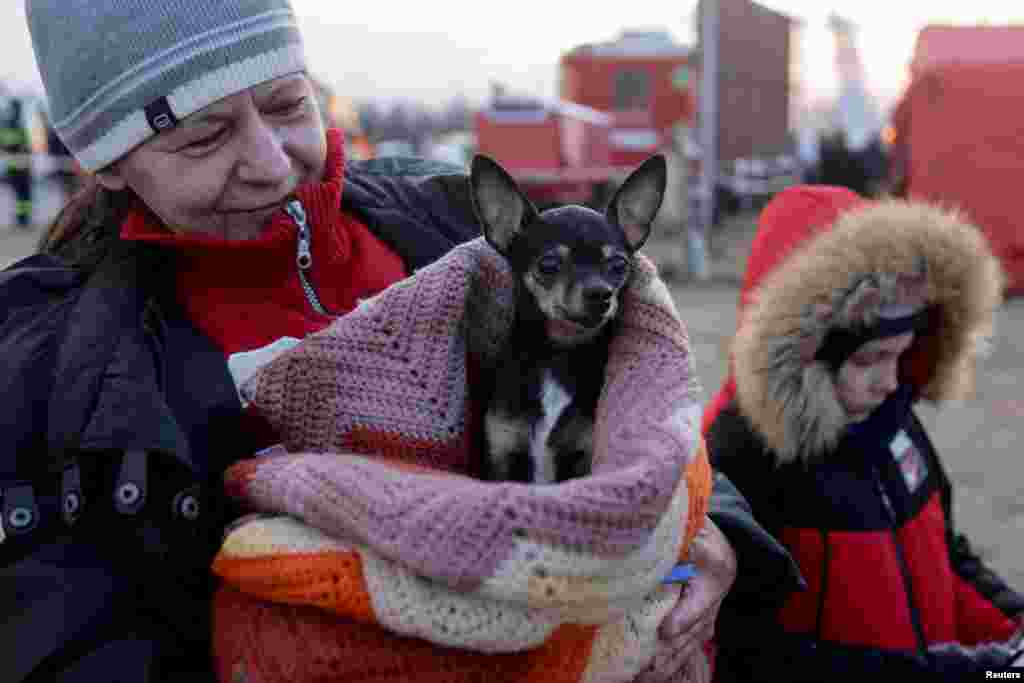 Жінка тримає собаку, перетинаючи разом із іншими біженцями з України українсько-словацький кордон після вторгнення Росії в Україну, Вишне Немецке, Словаччина, 3 березня 2022 року
