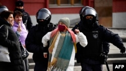 Police officers detain a woman during a protest against Russian military action in Ukraine in central Moscow on March 13.