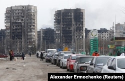 Zapaljene zgrade i kolona automobila koja pokušava izaći iz opkoljenog Mariupolja, 17. mart.
