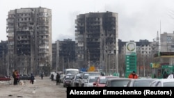 Pogled prikazuje red automobila u blizini stambenih blokova uništenih tokom bombardovanja Mariupolja, Ukrajina, 17. marta 2022.