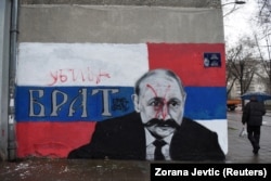 A mural in Belgrade depicting Russian President Vladimir Putin that has been vandalized with red spray paint and the word "Murderer" written above the original text, which said: "Brother," following Russia's invasion of Ukraine.