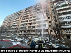  Спасители гасят пожар в жилищна постройка, развалена от обстрел, в Киев, 15 март 2022 година 