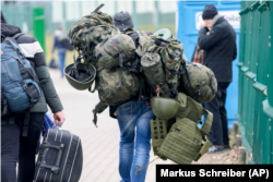 Muškarac nosi borbenu opremu dok napušta Poljsku da se bori u Ukrajini, na graničnom prijelazu u Mediki, Poljska, srijeda, 2. marta 2022.