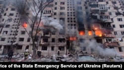 Rescuers work next to a residential building damaged by shelling in Kyiv on March 14. 