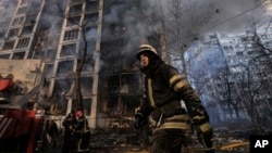 A firefighter works outside a destroyed apartment building after a bombing in a residential area in Kyiv on March 15.