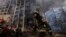 A firefighter works outside a destroyed apartment building after a bombing in a residential area in Kyiv on March 15.