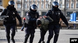 Russian police officers detain an anti-war protester in central Moscow on March 13. 