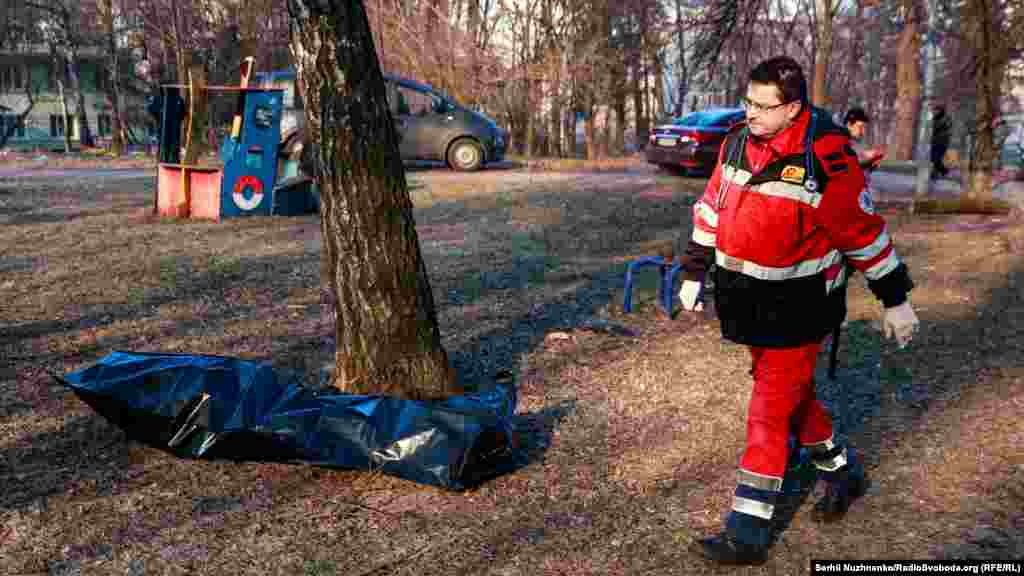 Рятувальник проходить повз тіло загиблої людини внаслідок обстрілу російською армією&nbsp; житлового будинку в Святошинському районі. Київ, 15 березня 2022 року
