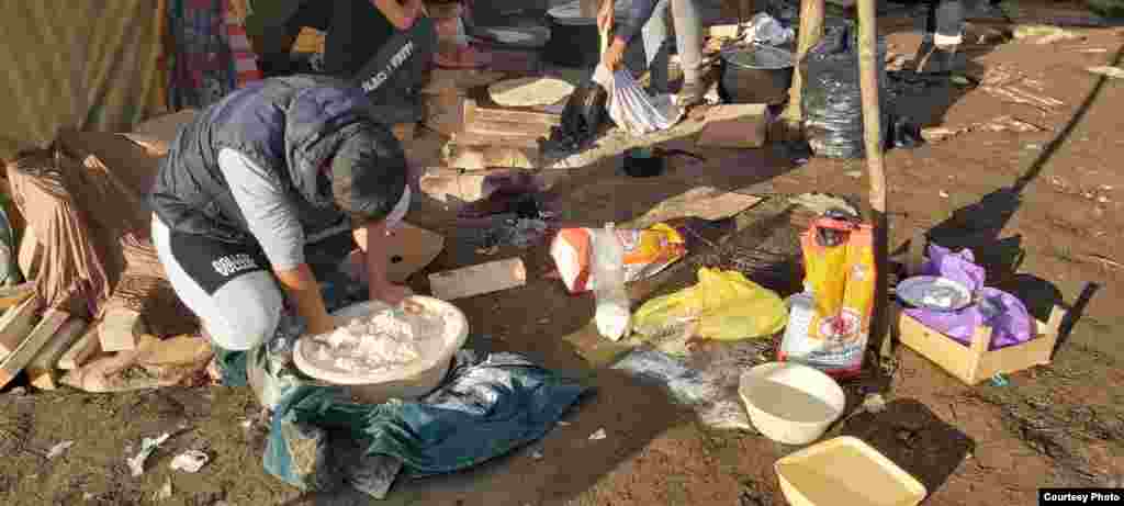 Pored improvizovanih šatora, migranti pripremaju hranu.&nbsp;