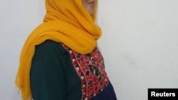 Беременная афганская летчица, прошедшая обучение в США, которая содержался в санатории и попросила скрыть ее лицо и имя из соображений безопасности, позирует для фотографии в Таджикистане. 5 октября 2021 года.