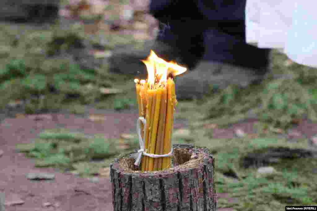 A cluster of candles burn inside a tree stump in the forest. The October prayers mark thirty years since the resumption of openly held Mari rituals after decades of repression by the Soviet authorities.