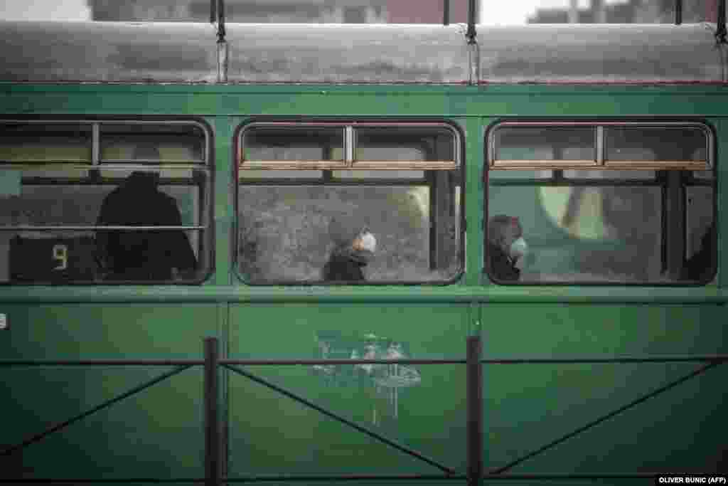 Passengers wearing face masks ride a tram in Belgrade amid a new surge in coronavirus infections in Serbia.&nbsp;