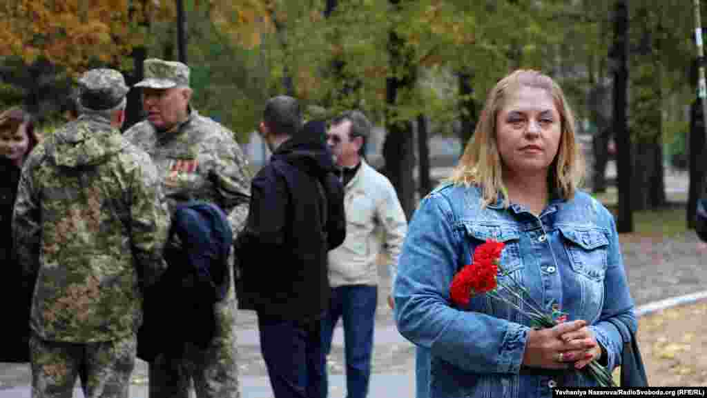 A woman holds a flower during the march in Zaporizhzhya.