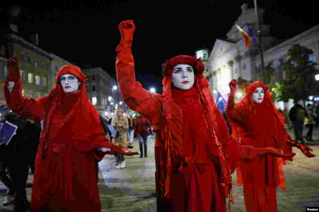 Маскирани протестиращи в костюми с цветовете на полското знаме шестваха по улиците във Варшава.
