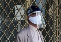 An Iranian man wearing personal protective equipment shops at the Grand Bazaar in the capital, Tehran.