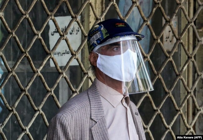 An Iranian man wearing personal protective equipment shops at the Grand Bazaar in the capital, Tehran.