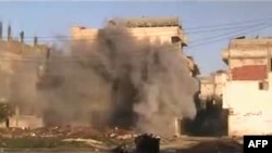 A photo from a video grab shows shells hitting a building in the neighborhood of Baba Amr in the flashpoint city of Homs on February 21.