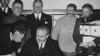 Foreign Minister Vyacheslav Molotov signs the pact. Behind him are Ribbentrop and Stalin 