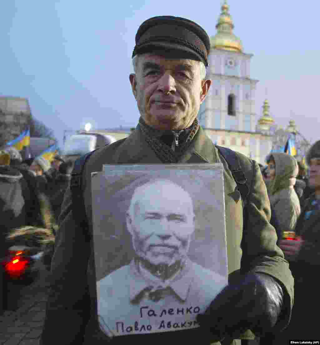 Viktor Golenko din satul Romnî, la o acțiune comemorativă în capitala Ucrainei, în noiembrie 2005, ținând fotografia tatălui său Pavlo, care a murit în perioada Holodomorului, în 1932.