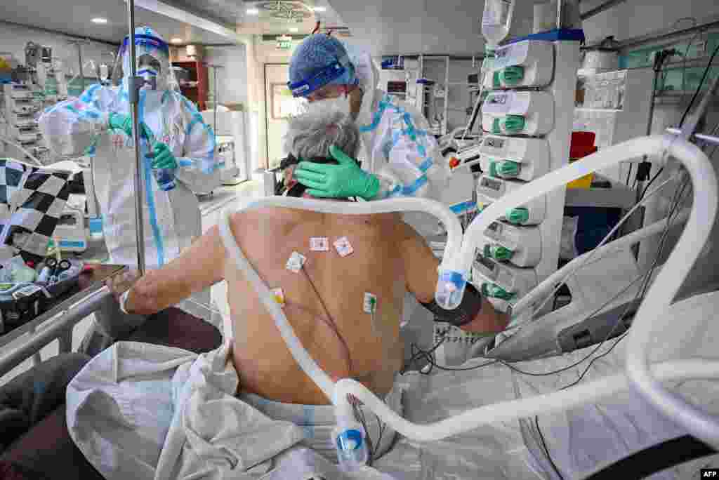 Punëtorët shëndetësorë kujdesen me një pacient me COVID-19 në që gjendet në repartin e kujdesit intensiv në një spital në Bukuresht të Rumanisë.