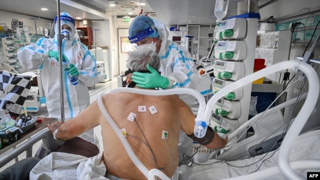 Personalul medical îngrijesc un pacient infectat cu Covid în interiorul unui spital mobil. 