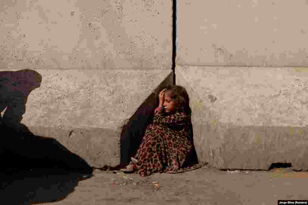 Egy kislány üldögél Kabul egyik utcáján október 7-én