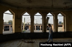 A man inspects the damage at the Sayed Abad Shi'ite mosque in Kunduz the day after a suicide bombing targeted worshippers on October 8.