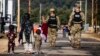 U.S. military police walk past Afghan refugees at the Ft. McCoy U.S. Army base in Wisconsin on September 28.