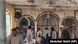 People view the damage inside a mosque following a bombing in the northern province of Kunduz on October 8.