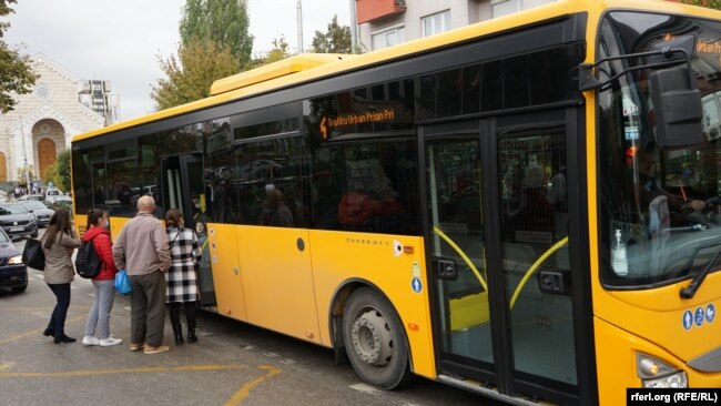 Një autobus i trafikut urban duke u ngarkuar me udhëtarë.