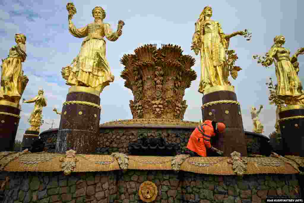 A municipal worker cleans the Druzhba Narodov (Friendship of Nations) fountain at the All-Russia Exhibition Centre in Moscow.&nbsp;