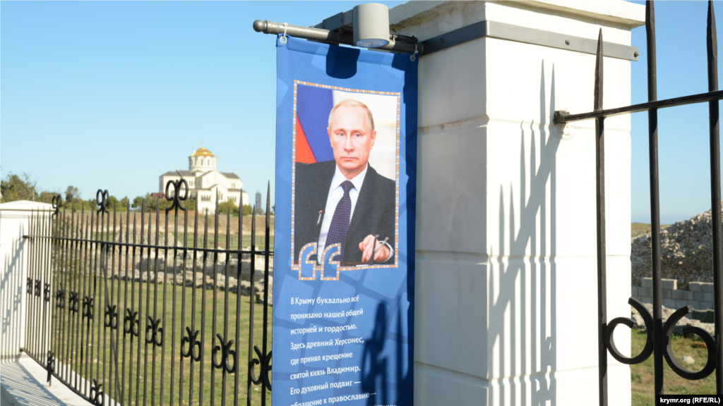 Банер з портретом і висловлюванням російського президента Володимира Путіна зустрічає відвідувачів біля запасного входу в заповідник