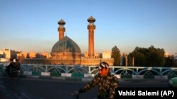 A man drives past a closed mosque on his motorcycle during the Muslim holy fasting month of Ramadan, in southern Tehran, April 27, 2020