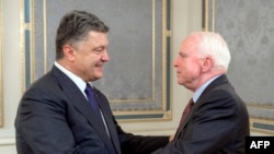 Прэзыдэнт Украіны Пятро Парашэнка (зьлева) вітае сэнатара ЗША Джона Маккейна падчас перамоваў у Кіеве, 20 чэрвеня 2015 году