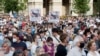 Demonstrators hold up signs depicting Hungarian Prime Minister Viktor Orban as Mao Tse-tung at a protest against the planned Chinese Fudan University campus in Budapest on June 5.