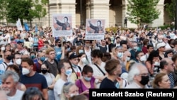 Demonstrators hold up signs depicting Hungarian Prime Minister Viktor Orban as Mao Tse-tung at a protest against the planned Chinese Fudan University campus in Budapest on June 5.