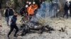 Rescue workers and police officers gather at the site of a suicide car bombing in Islamabad on December 23.