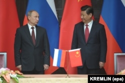 Президент России Владимир Путин (слева) и китайский лидер Си Цзиньпин