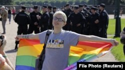 O participantă la demonstrația LGBT St Petersburg Pride VIII, St Petersburg, cu polițiști în fundal, St. Petersburg, 12 august 2017. REUTERS/Anton Vaganov