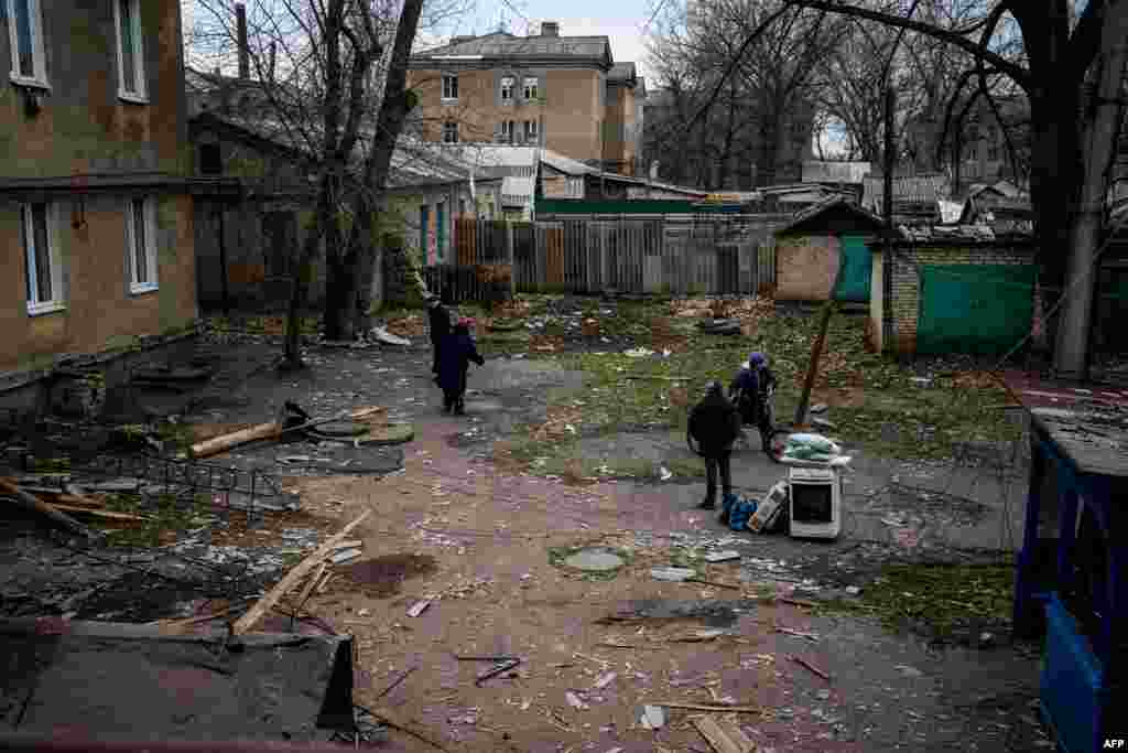 Egy rakétacsapásban megrongálódott ház idős lakosai gyűjtik össze holmijukat az épület udvarán.