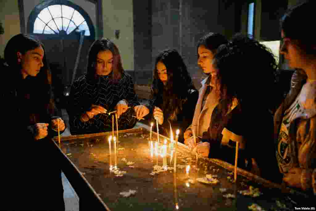 Membrele trupei Asparez, un grup de dans din Stepanakert, aprind lumânări într-o biserică din Goris. Adolescentele călătoreau împreună cu profesorul lor, Lari Avanesian (a doua din stânga), pentru a participa la un concurs de dans la Tbilisi, când drumul de întoarcere spre casele lor a fost închis.