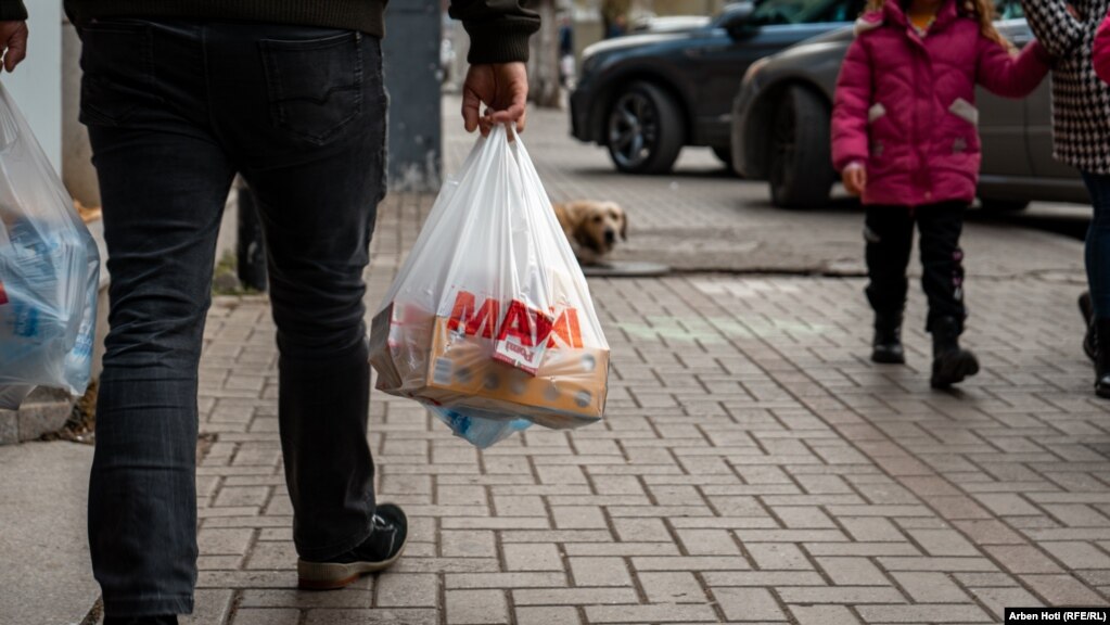 Një qytetar kalon në rrugët e Prishtinës me qese të plastikës të mbushura me produkte. Kosova synon që qeset e plastikës t'i bëjë me pagesë.