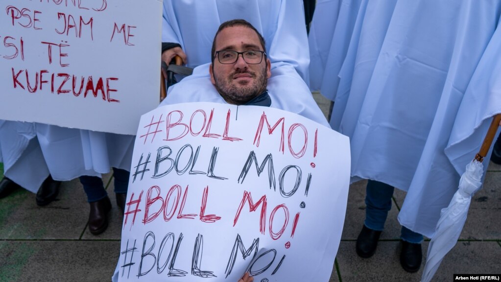 Një pjesëmarrës në protestë duke mbajtur një pankartë me mbishkrime "Boll ma". 