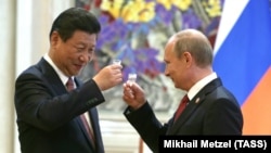 Фото від 21 травня 2014 року. Голова Китаю Сі Цзіньпін (ліворуч) і президент Росії Володимир Путін після підписання спільних документів
