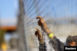 Venezuelanski migrant, protjeran iz SAD-a i poslan natrag u Meksiko pod Članom 42, drži se za ogradu zgrade Nacionalnog instituta za migracije (INM) u Ciudad Juarezu, Meksiko, 6. januara 2023.