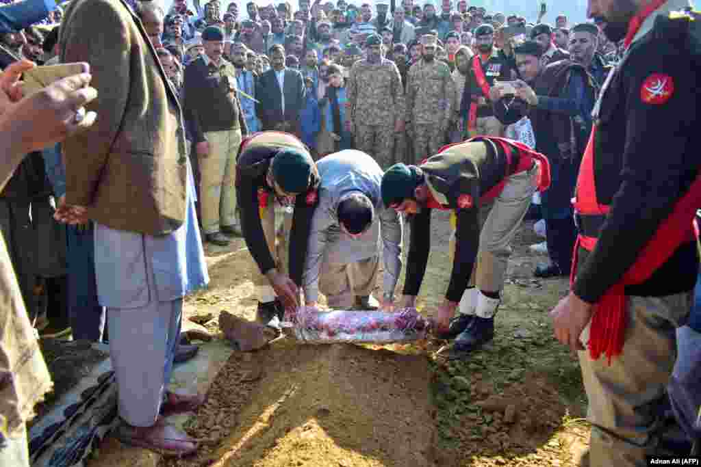 Soldați depun jerbe de flori pe mormântul unui soldat ucis într-o explozie sinucigașă în Miran Shah, un oraș din districtul Waziristanul de Nord din Pakistan.